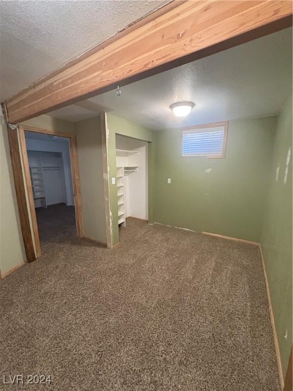 basement with carpet flooring and a textured ceiling