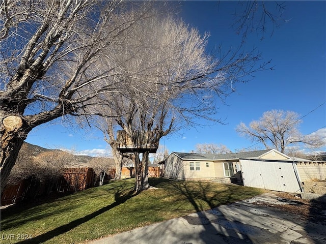 view of front of home with a mountain view and a front lawn