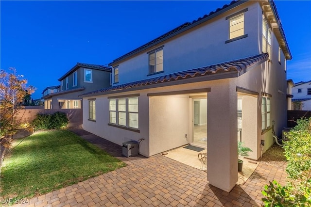 rear view of property featuring a lawn and a patio area