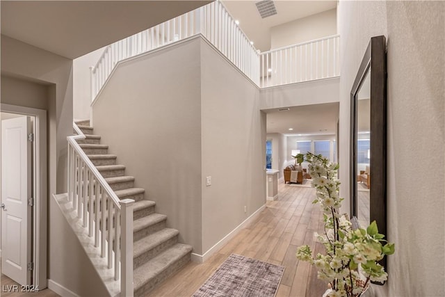 entryway featuring light hardwood / wood-style floors and a high ceiling