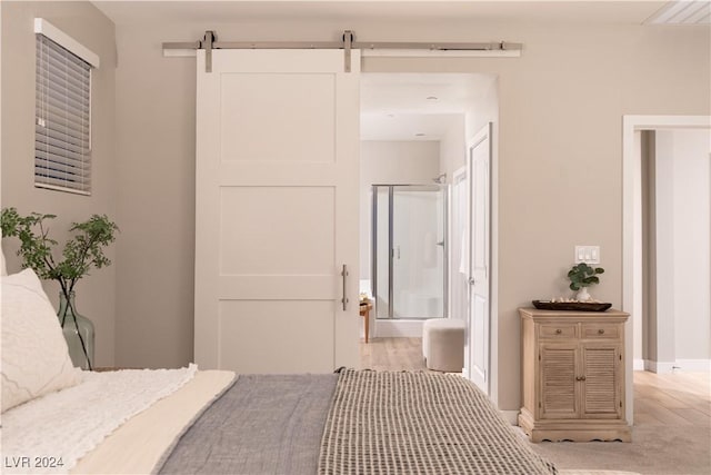 bedroom featuring ensuite bathroom and a barn door