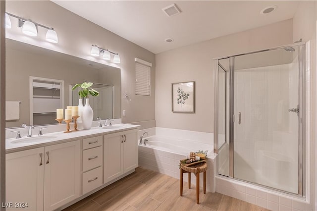 bathroom with vanity and shower with separate bathtub