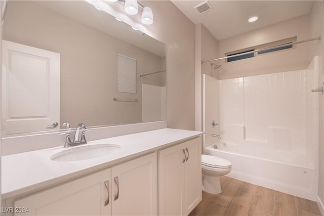 full bathroom featuring hardwood / wood-style floors, vanity, shower / bath combination, and toilet