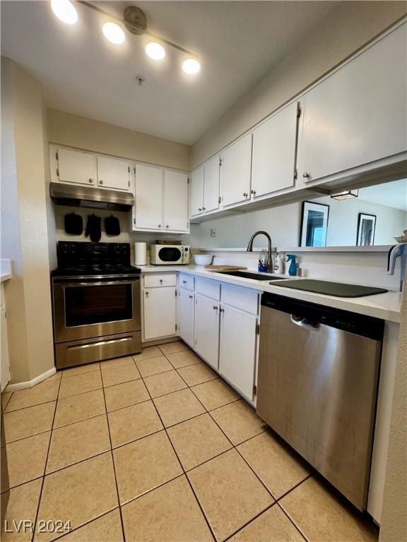 kitchen featuring light tile patterned flooring, stainless steel appliances, white cabinetry, and sink