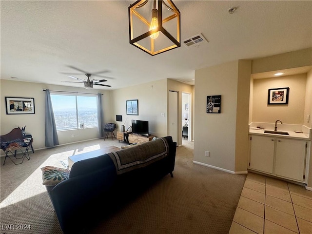 living room with light colored carpet, ceiling fan, and sink