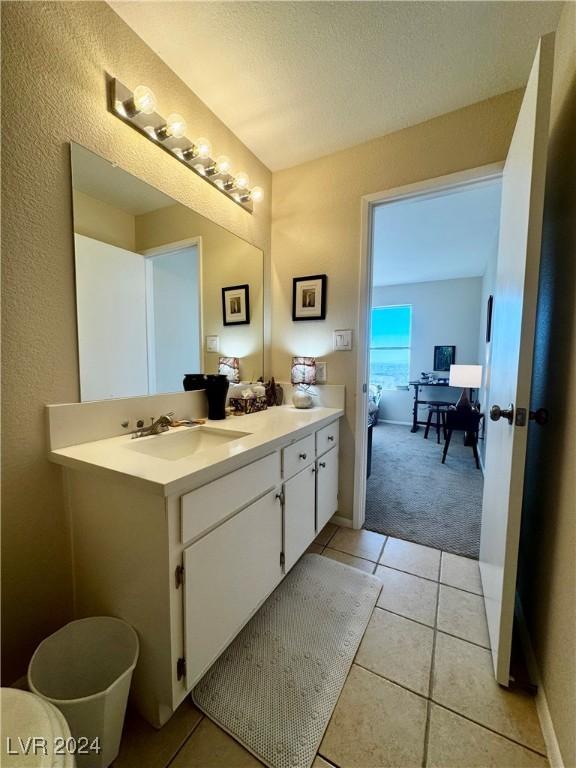 bathroom with a textured ceiling, vanity, and tile patterned floors