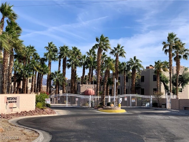 view of street featuring a gated entry, a gate, and curbs