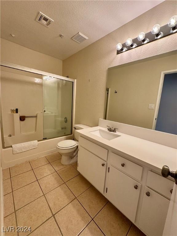 full bath with a textured ceiling, visible vents, tile patterned floors, vanity, and toilet