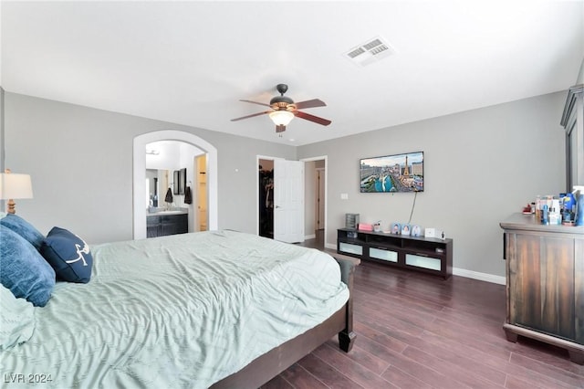 bedroom with ceiling fan, a spacious closet, connected bathroom, dark hardwood / wood-style floors, and a closet