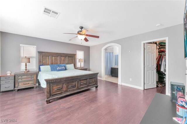 bedroom featuring ensuite bath, ceiling fan, a spacious closet, dark hardwood / wood-style floors, and a closet