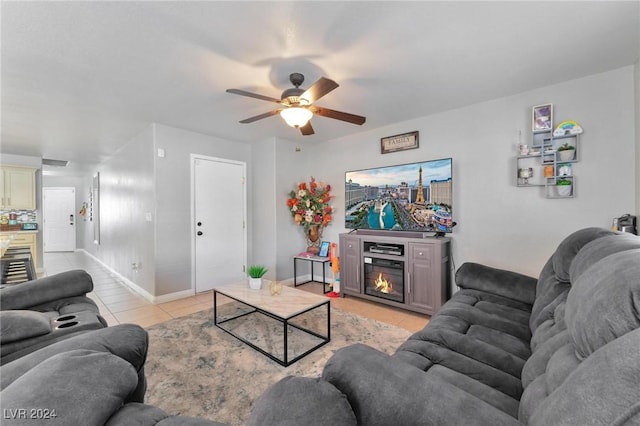 tiled living room featuring ceiling fan and a fireplace