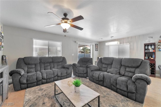 tiled living room featuring an AC wall unit and ceiling fan