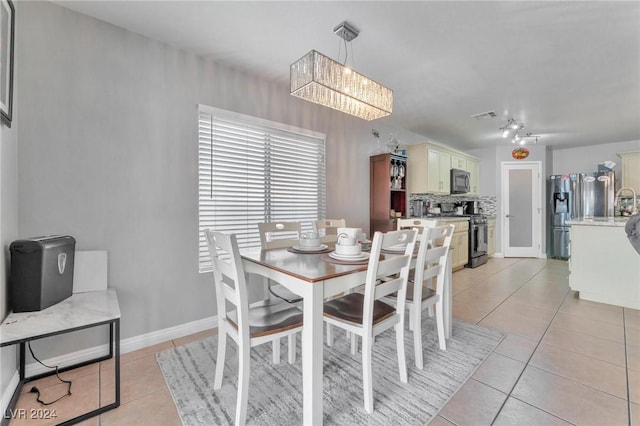 dining area with light tile patterned floors and a notable chandelier