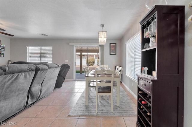 tiled dining area with ceiling fan and a healthy amount of sunlight