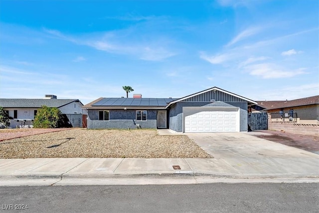 ranch-style house with solar panels and a garage