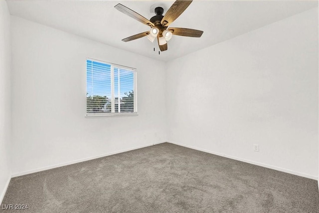 empty room with dark colored carpet and ceiling fan