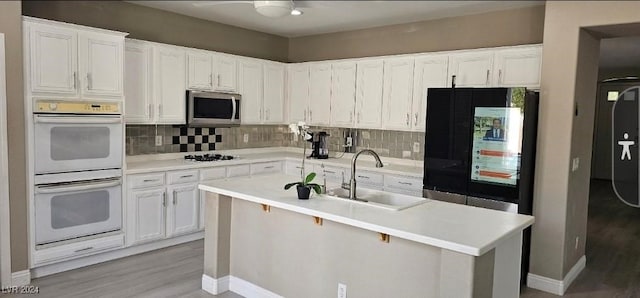 kitchen with backsplash, white cabinetry, sink, and appliances with stainless steel finishes