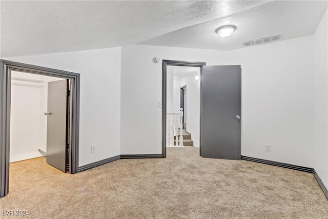 carpeted empty room with a textured ceiling