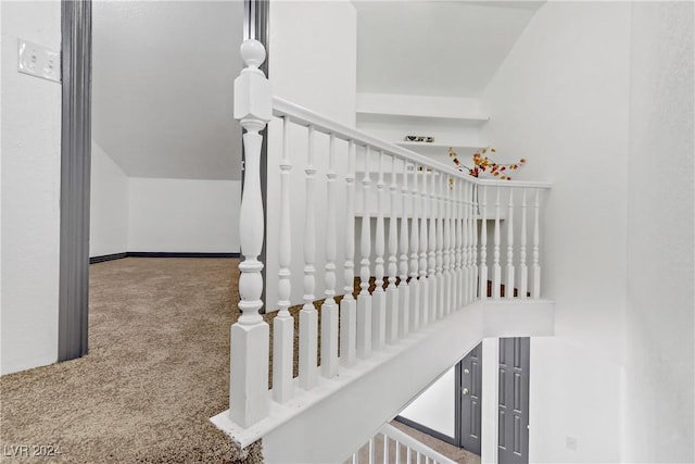 stairway with carpet flooring and vaulted ceiling