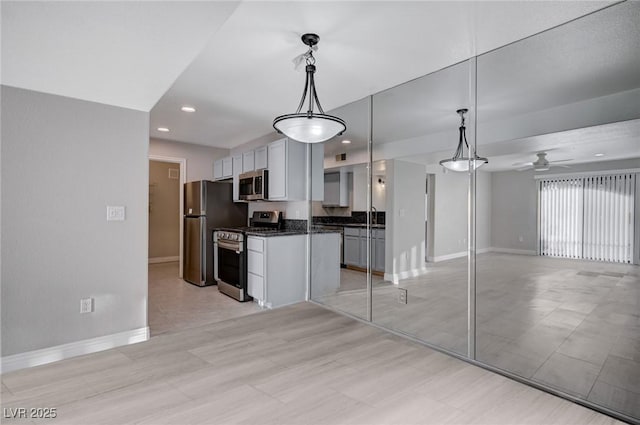 kitchen with appliances with stainless steel finishes, decorative light fixtures, ceiling fan, and sink