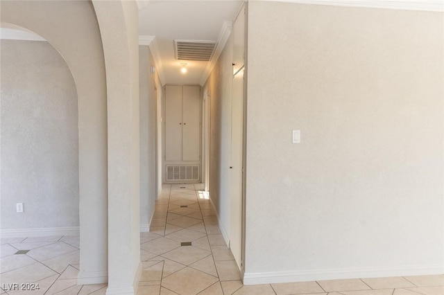 corridor with light tile patterned floors and crown molding