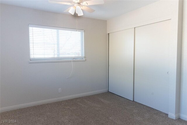 unfurnished bedroom featuring carpet floors, a closet, and ceiling fan