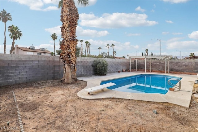 view of swimming pool featuring a diving board