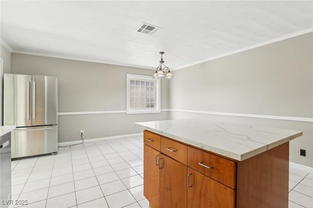 kitchen with a center island, hanging light fixtures, light tile patterned floors, stainless steel refrigerator, and ornamental molding