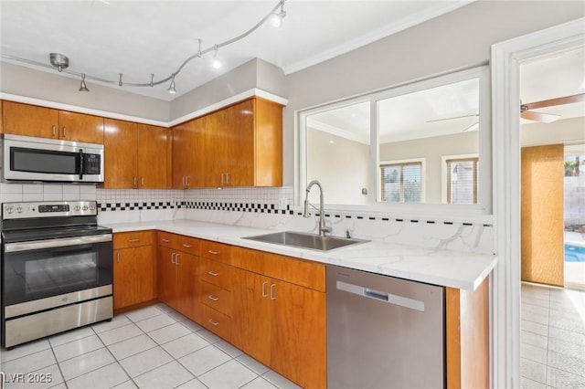 kitchen with stainless steel appliances, tasteful backsplash, sink, and light tile patterned floors