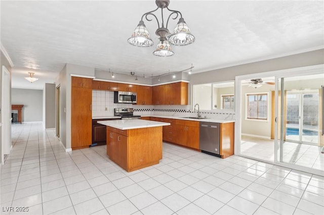 kitchen with sink, hanging light fixtures, stainless steel appliances, a center island, and tasteful backsplash