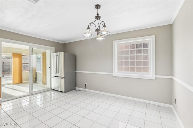 tiled spare room featuring ornamental molding, plenty of natural light, and a chandelier