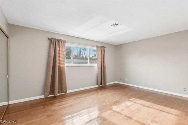 empty room with hardwood / wood-style flooring