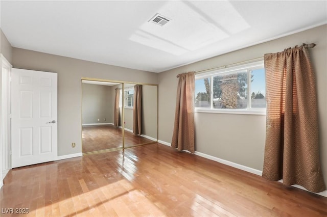 unfurnished bedroom with hardwood / wood-style floors and a closet