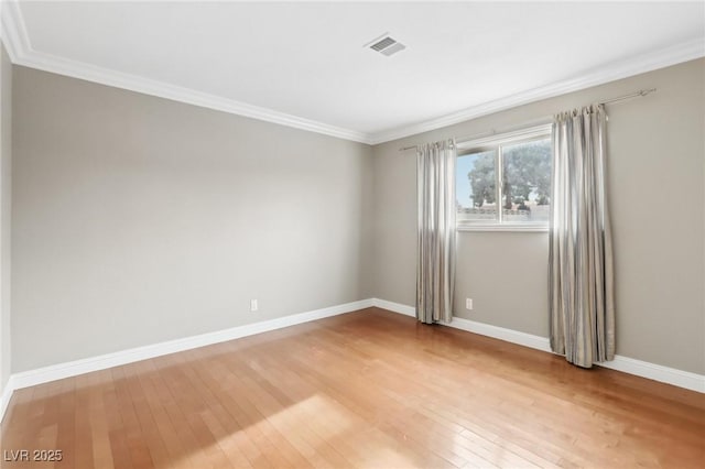 spare room with crown molding and hardwood / wood-style floors