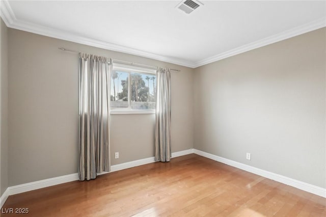 spare room with crown molding and hardwood / wood-style floors