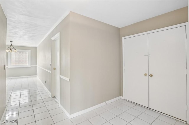 foyer featuring ornamental molding, light tile patterned floors, and a notable chandelier