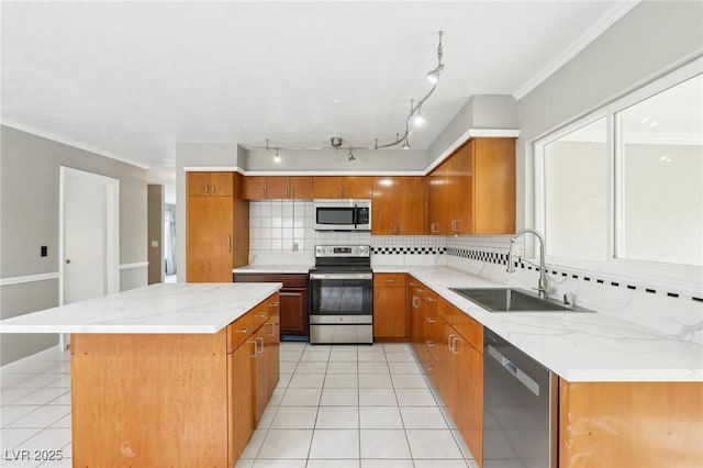 kitchen featuring stainless steel appliances, sink, a kitchen island, and light tile patterned floors