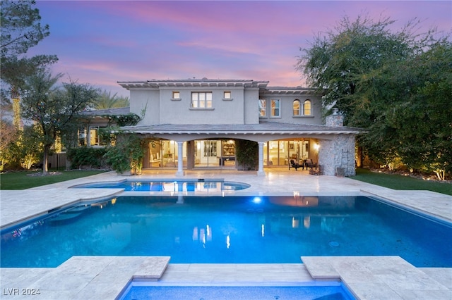 pool at dusk featuring a patio