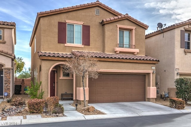 mediterranean / spanish-style home with a garage