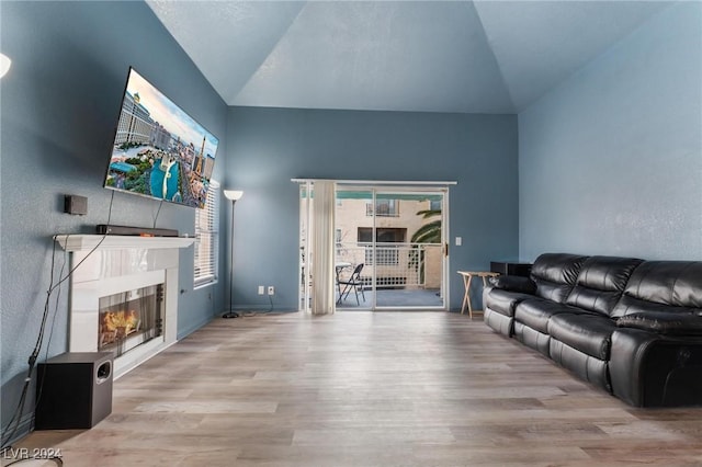 living room with plenty of natural light, light hardwood / wood-style floors, and lofted ceiling