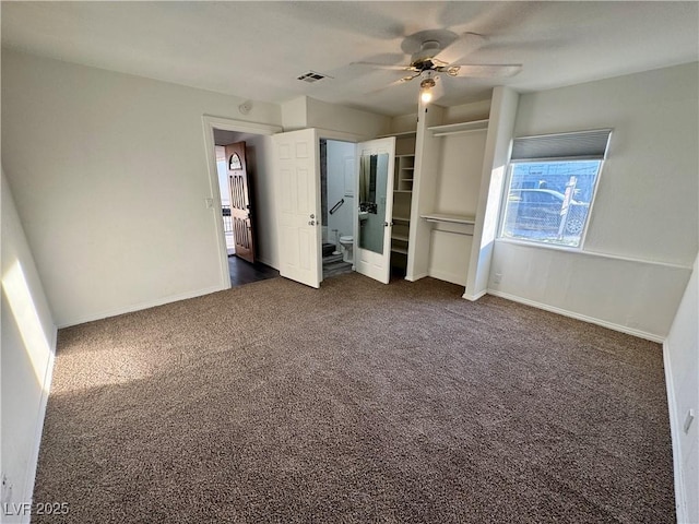 unfurnished bedroom with dark colored carpet, a ceiling fan, visible vents, and baseboards