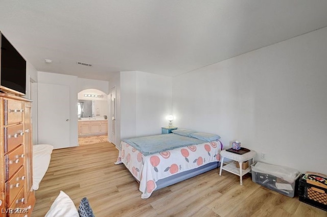 bedroom featuring light hardwood / wood-style floors and connected bathroom