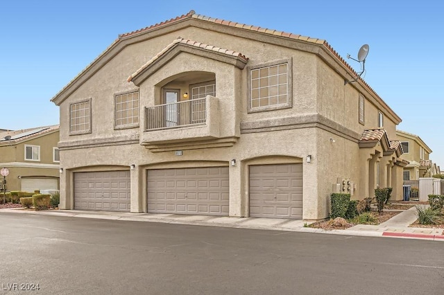 view of front of property featuring a garage and a balcony