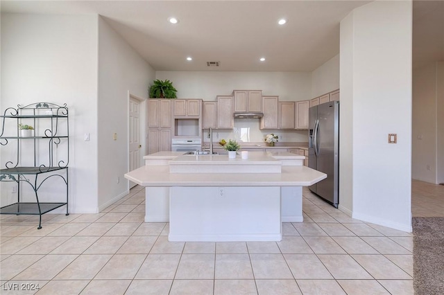 kitchen featuring stainless steel fridge with ice dispenser, a center island with sink, light tile patterned floors, and sink