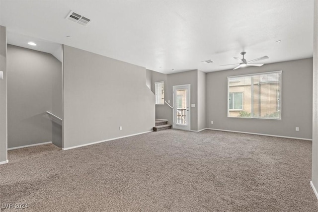 unfurnished living room featuring ceiling fan and carpet floors