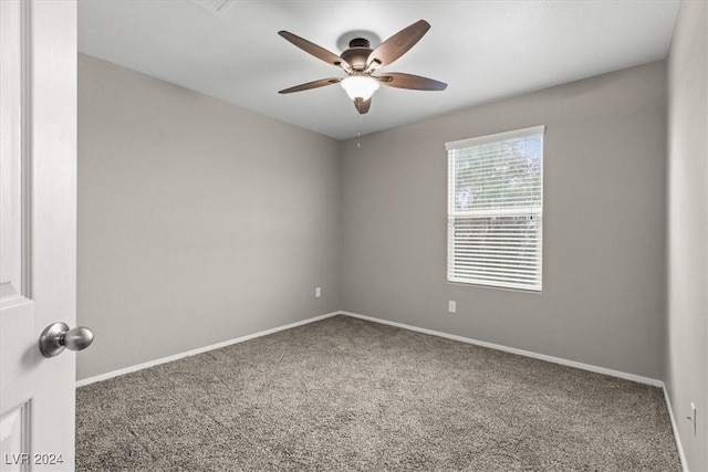 carpeted spare room featuring ceiling fan