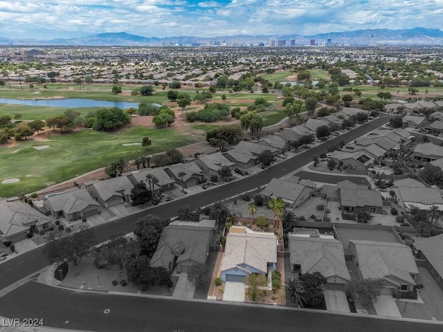 drone / aerial view featuring golf course view, a residential view, and a water and mountain view