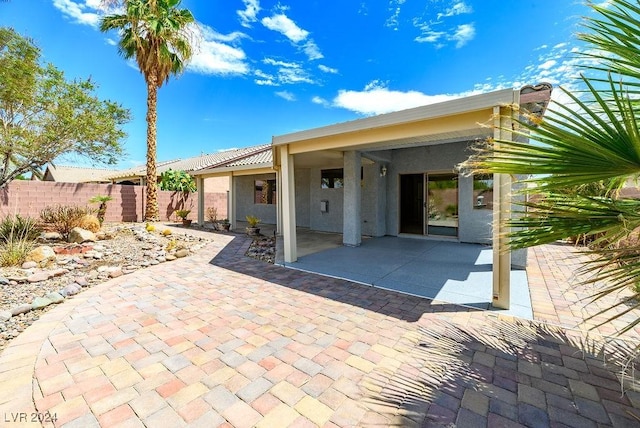 back of house featuring a patio area, fence, and stucco siding