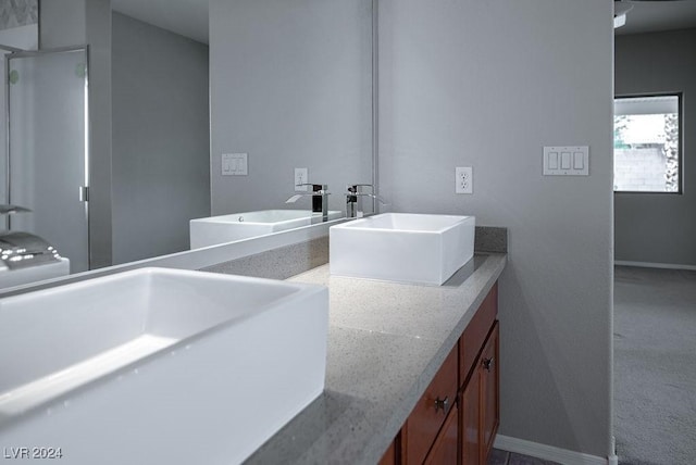 full bathroom with a sink, baseboards, and double vanity