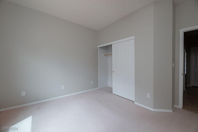 unfurnished bedroom featuring carpet, baseboards, and a closet